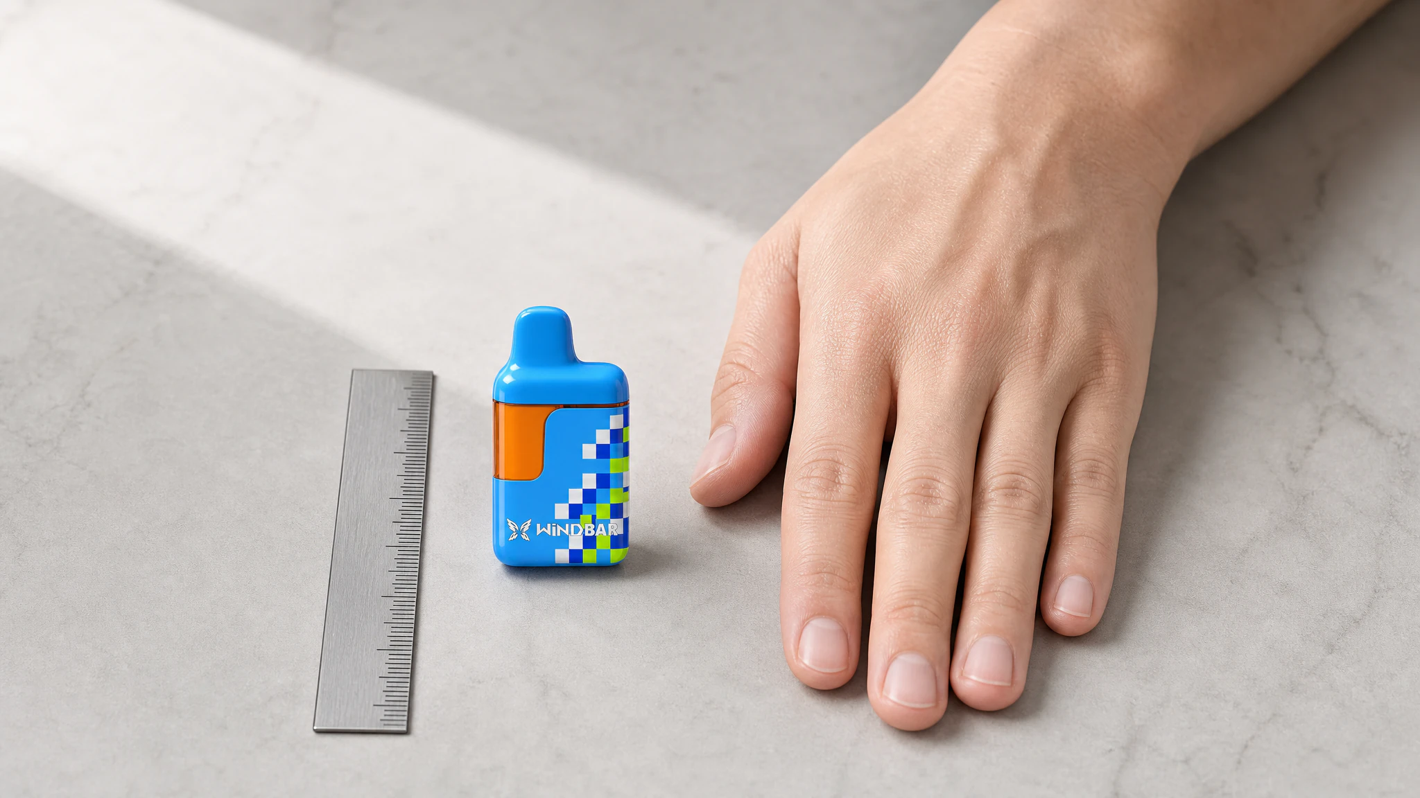 D95 Cool Blue Pixel shown beside an adult hand and reference ruler for compact scale